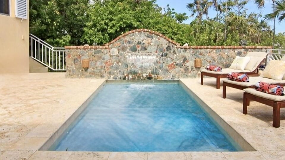 Spacious pool deck with sun loungers and tropical greenery—perfect for all-day lounging and dips.