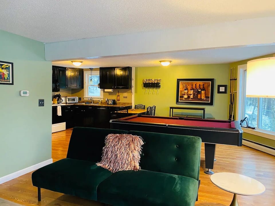First floor living room with 2 futon couches and pool table