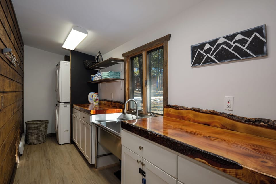 Cook your favorite meals in this fully-equipped galley kitchen featuring stunning live-edge wood countertops and modern appliances.