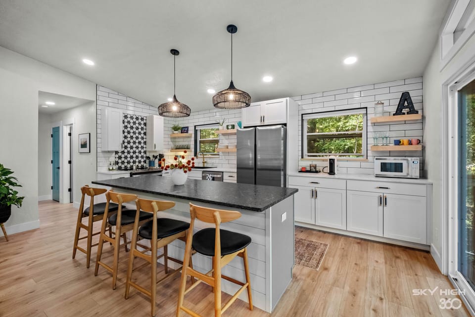 Chef’s kitchen with a beautiful island, coffee bar and a grill outside. 
