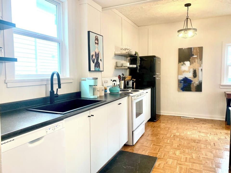 Fully equipped kitchen with stove, microwave, coffee maker, cookware, and dining essentials.