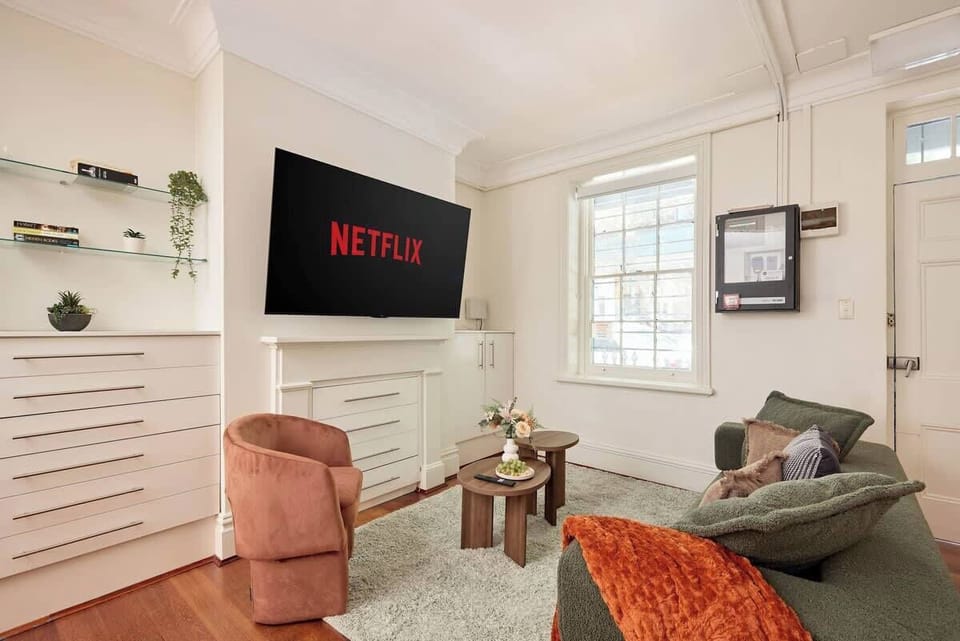  Living Room:
Bright living space featuring custom floating shelves with greenery, ample storage, and modern entertainment setup. Thoughtfully styled with coral and sage tones for contemporary comfort in a heritage terrace.