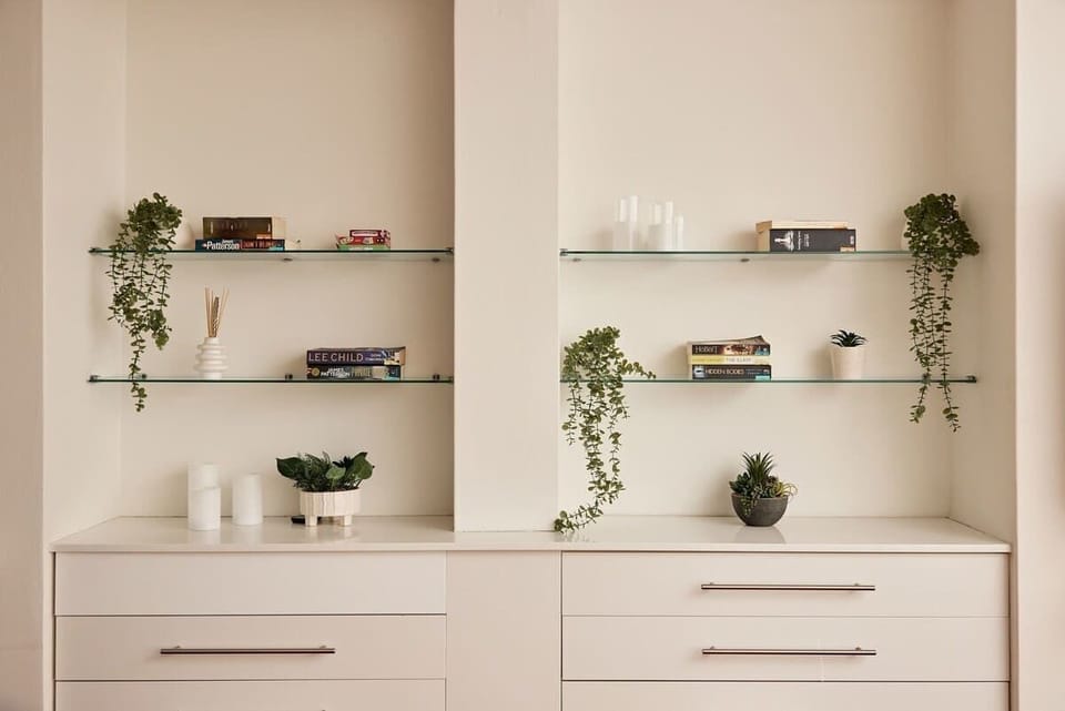 Display with Greenery:
Elegant floating glass shelves styled with cascading greenery, curated books, and designer touches. Thoughtful details and living plants create a fresh, sophisticated atmosphere for dining.