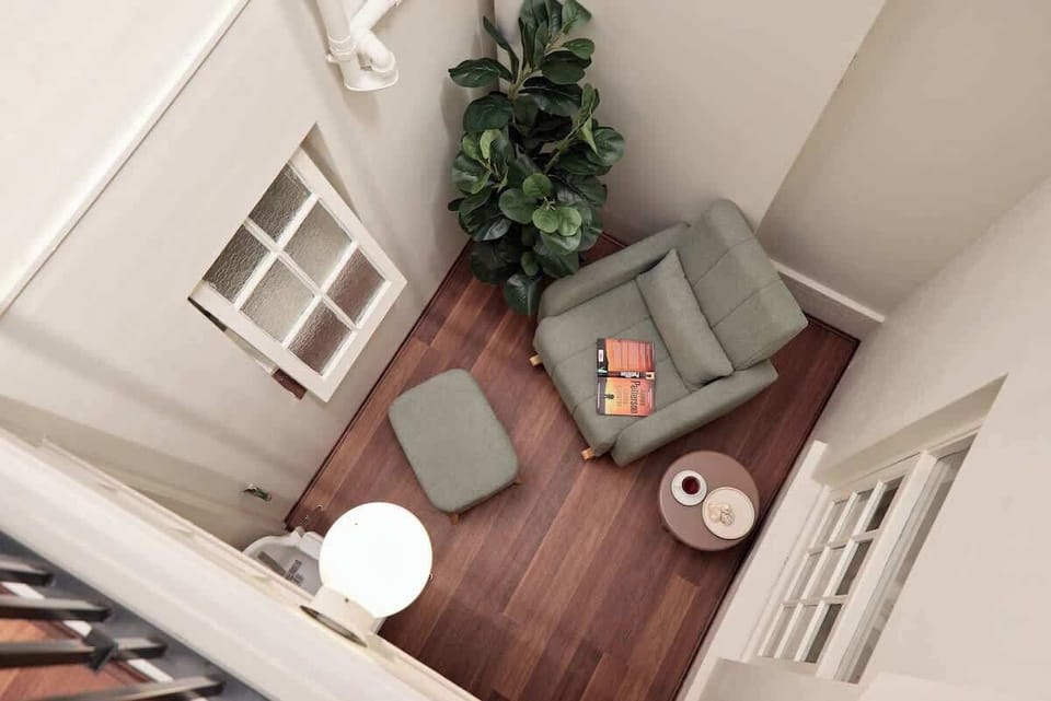 Sun-drenched reading retreat with cozy rocking chair and ottoman. Your favorite spot for morning coffee, afternoon books, or peaceful moments in natural light—a quiet sanctuary within.