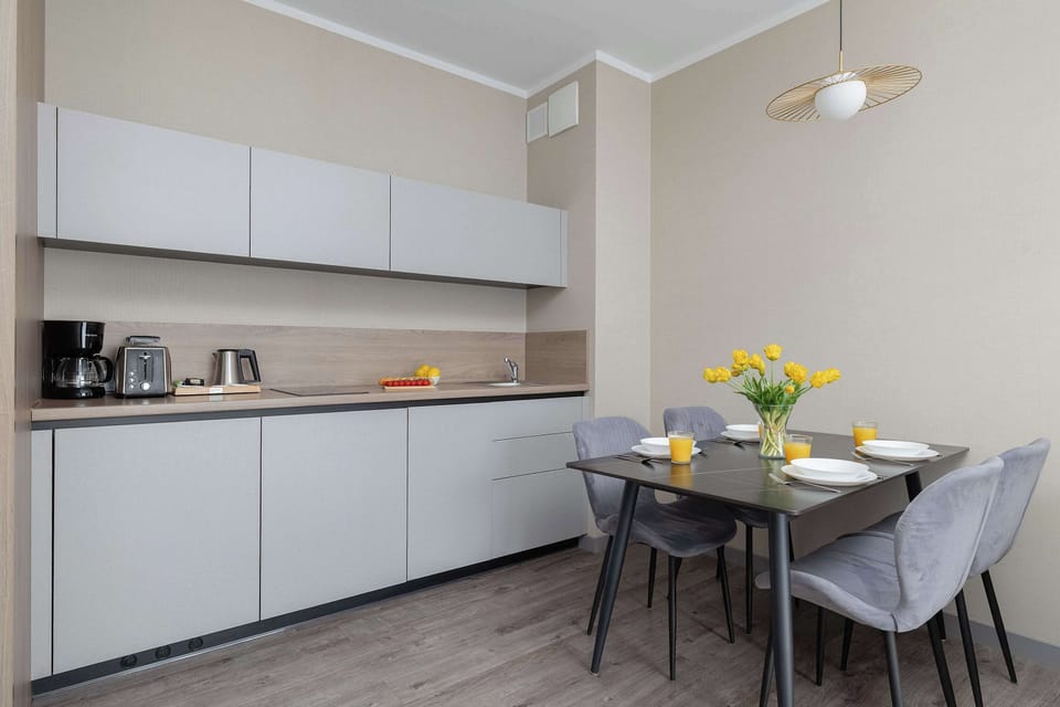 A modern kitchenette with sleek cabinets and built-in appliances. The clean lines emphasize practicality and elegance.
