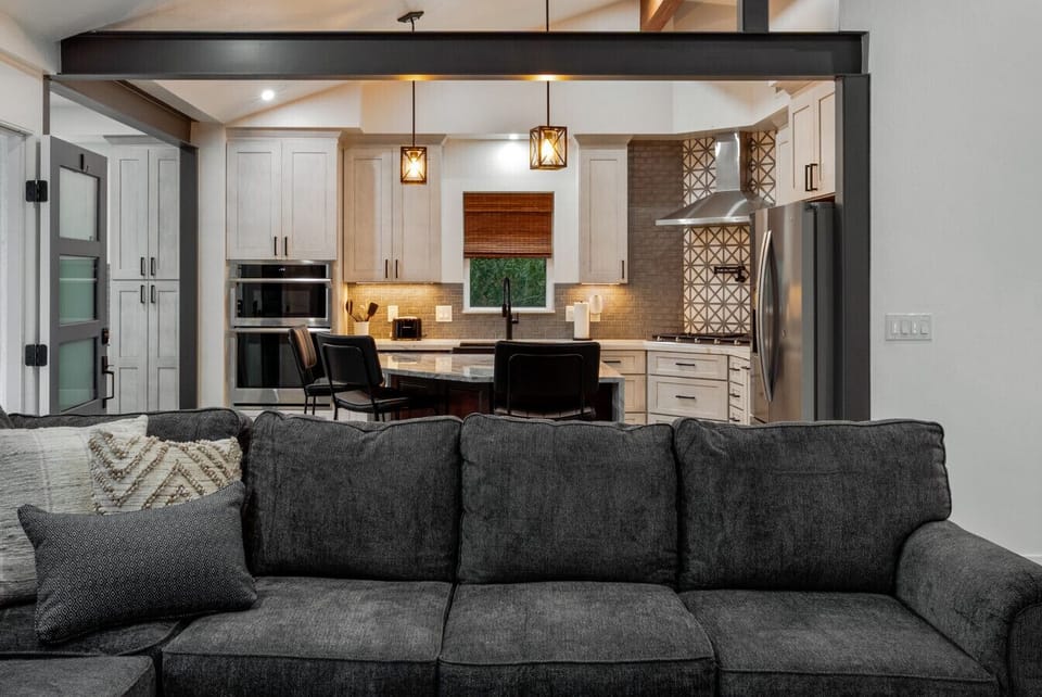 Living room`s cozy couch and updated, well-equipped kitchen