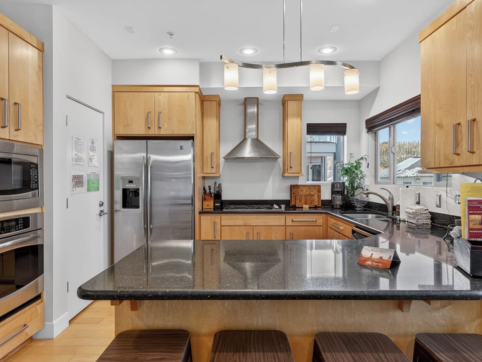 Your gourmet kitchen features granite countertops, stainless steel appliances, and warm wood cabinetry perfect for preparing memorable meals together.