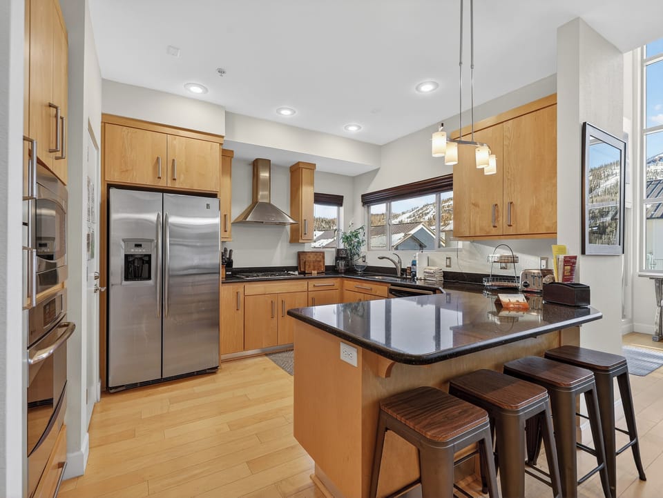 Your gourmet kitchen awaits with granite counters, stainless appliances, and mountain views—perfect for creating memorable meals together.