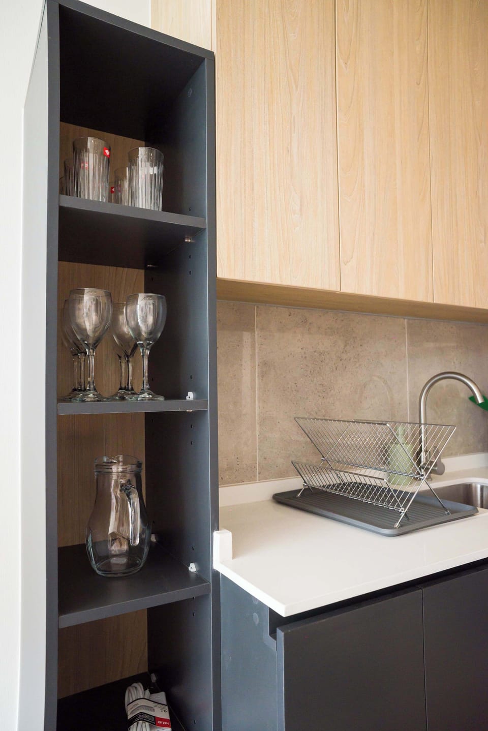 Modern kitchen with sleek cabinetry and ample glassware, perfect for preparing meals during your stay.