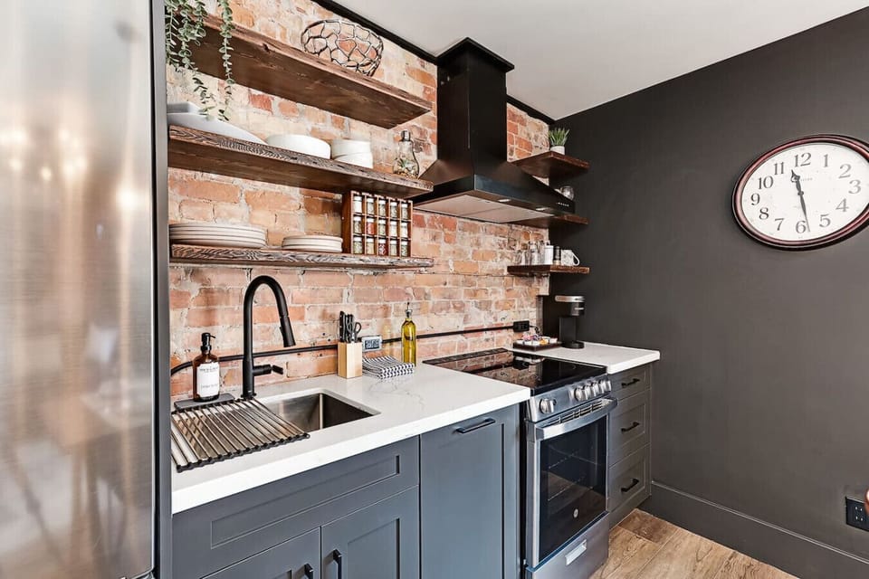 A fully equipped kitchen with restored-wood shelves, modern stainless steel appliances, dishwasher and everything you need for simple meals during your stay.