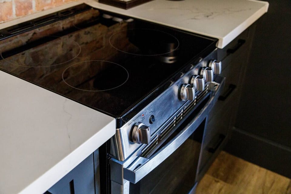 A modern cooktop and oven ready for simple meals, morning breakfasts, or a cozy dinner in.