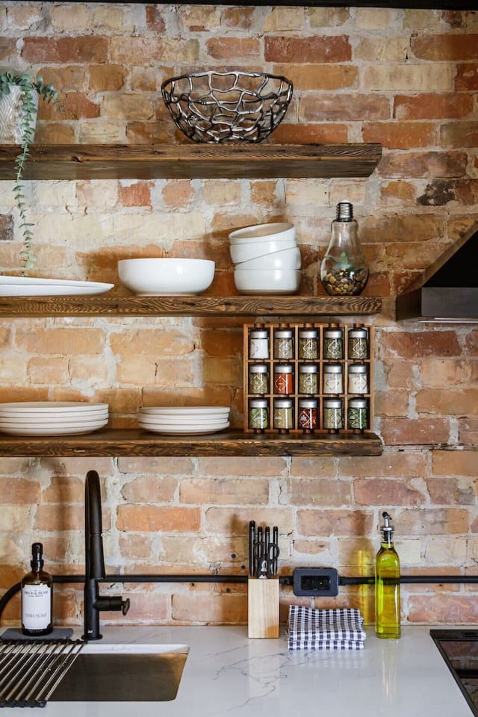 Open shelving made from original reclaimed wood provides convenient storage with a warm, historic touch.