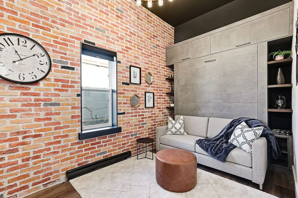 Tall 12-foot ceilings and exposed brick make this sitting area feel open and airy - a great spot to relax or enjoy your morning coffee.
