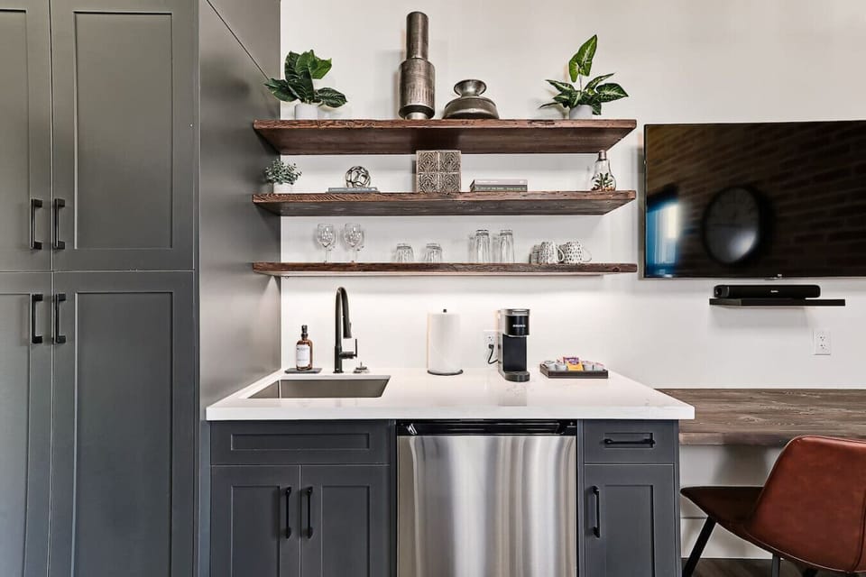 Open shelving made from restored 1800s wood keeps dishes and glassware within easy reach, adding warmth and character to this well-equipped kitchenette.