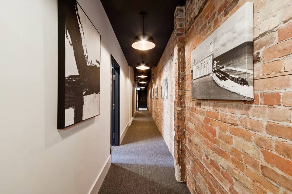 Original brick and warm lighting add charm and a heritage feel to the shared hallway.