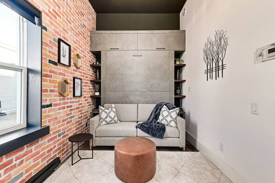 With the bed folded away, you get a spacious living area. The shelving on either side of the Murphy bed is built from restored 1800s wood, offering both storage and a meaningful heritage touch.