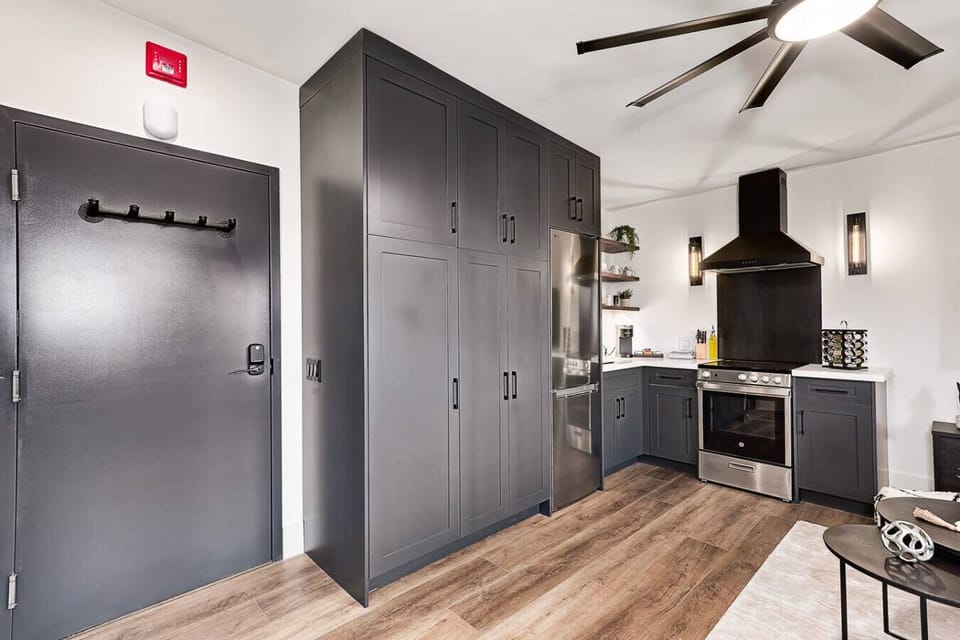 Full-size fridge and open shelving made from restored 1800s wood, keeping dishes and glassware organized and easy to access.