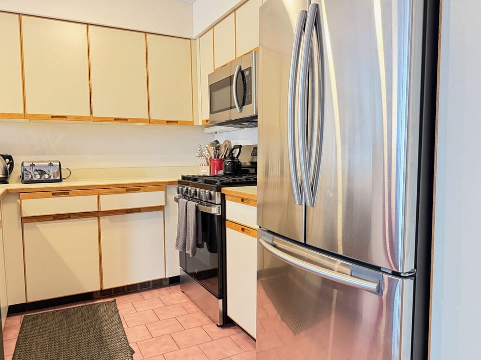 Cook like a pro in this modern kitchen equipped with a full-size stainless fridge.