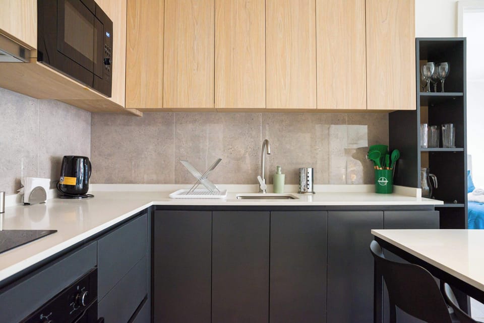 Sleek and modern kitchen with all essentials for a comfortable stay. Enjoy cooking in style with ample counter space and contemporary design.