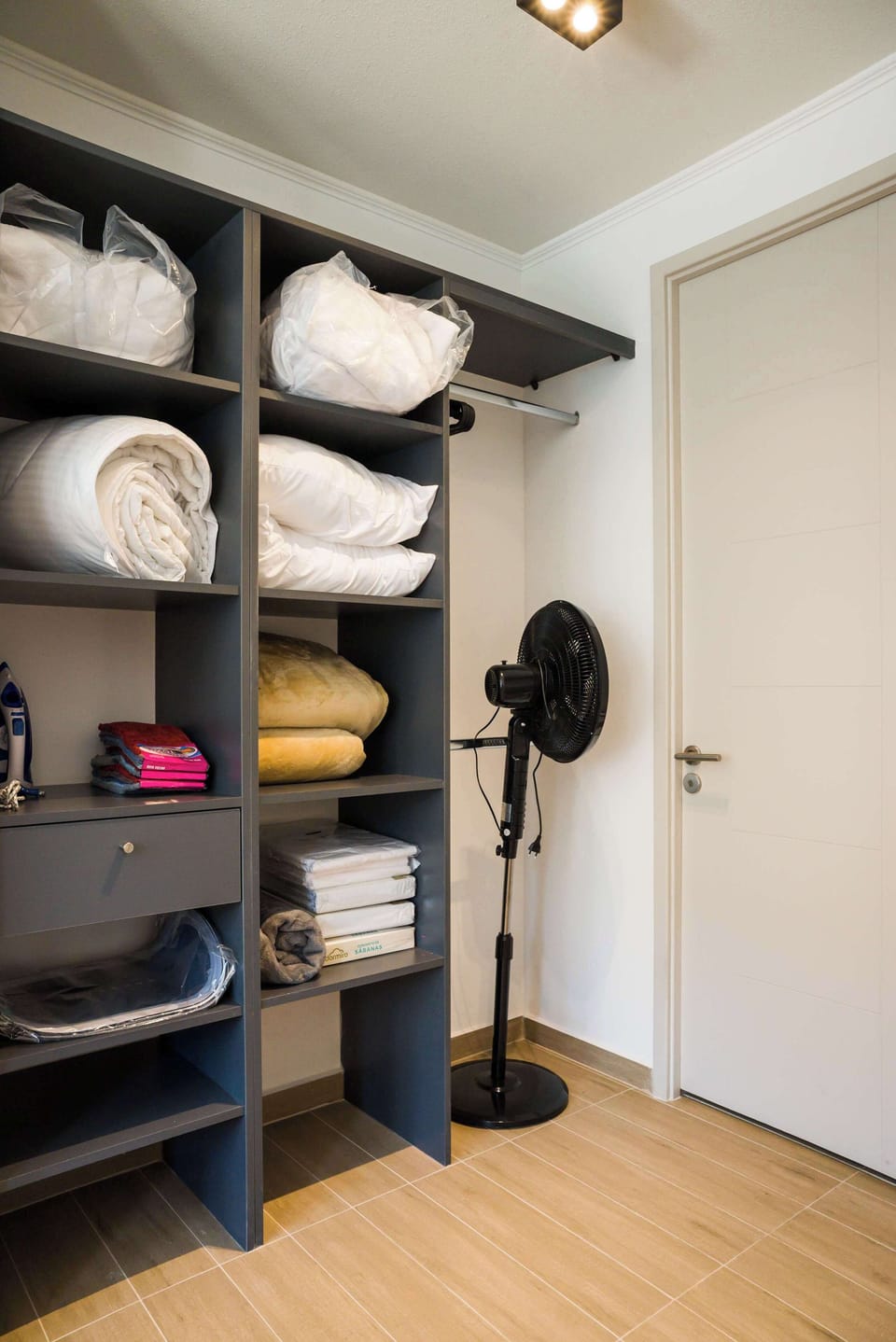 Organized storage with fresh linens and essentials for a comfortable stay.