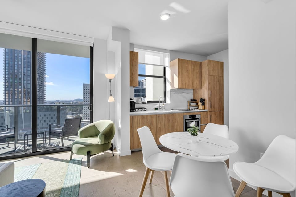 Open-concept living at its finest. The stylish kitchen blends into a chic dining space, perfectly positioned next to floor-to-ceiling windows and balcony access. Ideal for morning coffee with a downtown view
