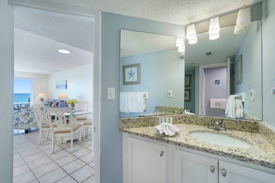Enjoy a clean, coastal-style bathroom with an updated vanity and plenty of storage in this Destin beachfront condo.