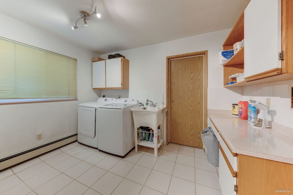 In-suite laundry with washer, dryer, and folding space.