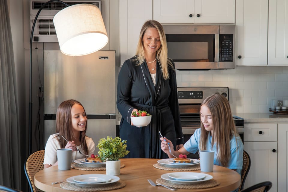Fully equipped kitchen with stove, oven, microwave, dishwasher, fridge with freezer, coffee machine, a dining table, and essential cookware and dinnerware—perfect for easy meals and relaxed dining.
