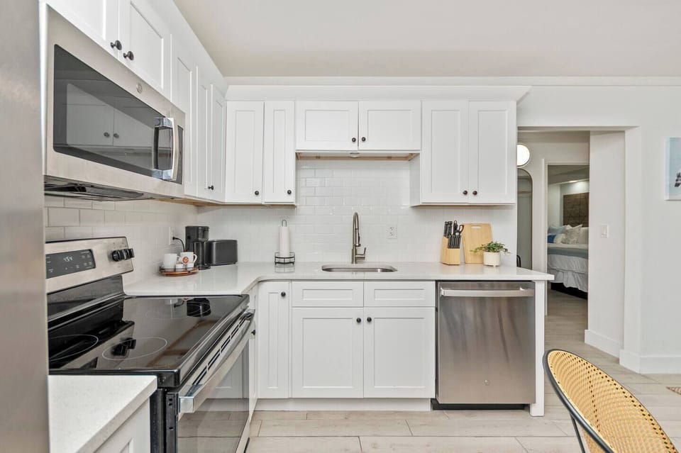 Fully equipped kitchen with stove, oven, microwave, dishwasher, fridge with freezer, coffee machine, a dining table, and essential cookware and dinnerware—perfect for easy meals and relaxed dining.