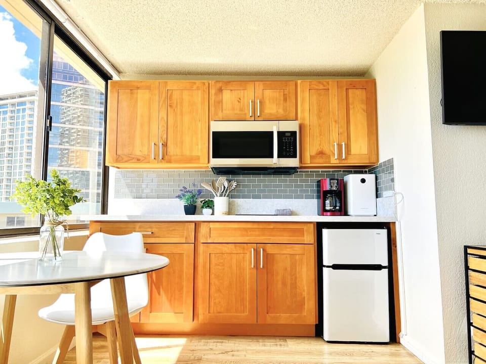 Kitchenette with induction cooktop, microwave, and kitchenware