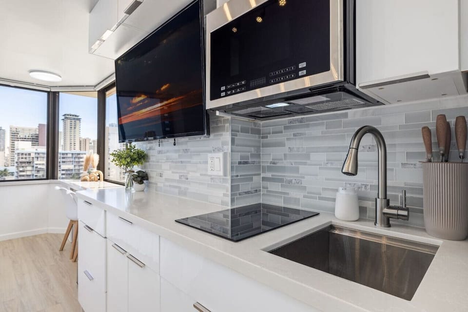 Kitchenette with induction cooktop, microwave, and kitchenware