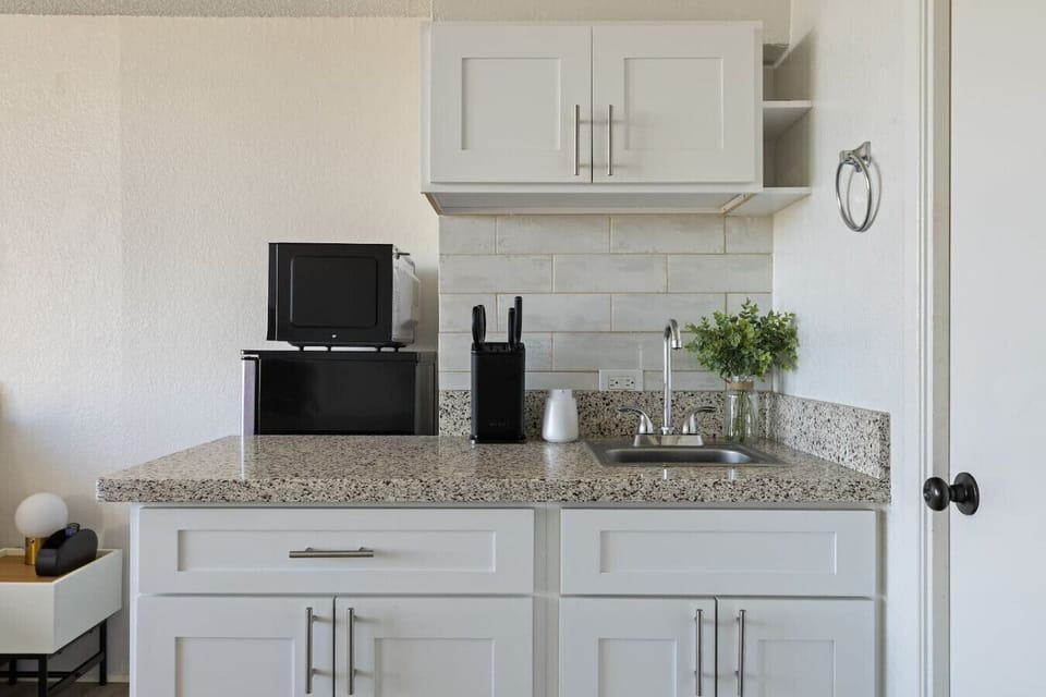 Bright and modern studio featuring a mini sink and counter space, perfect for preparing light meals during your getaway.