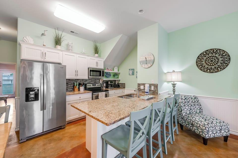 Your bright, spacious kitchen features granite counters, stainless appliances, and a breakfast bar where you can enjoy morning coffee.