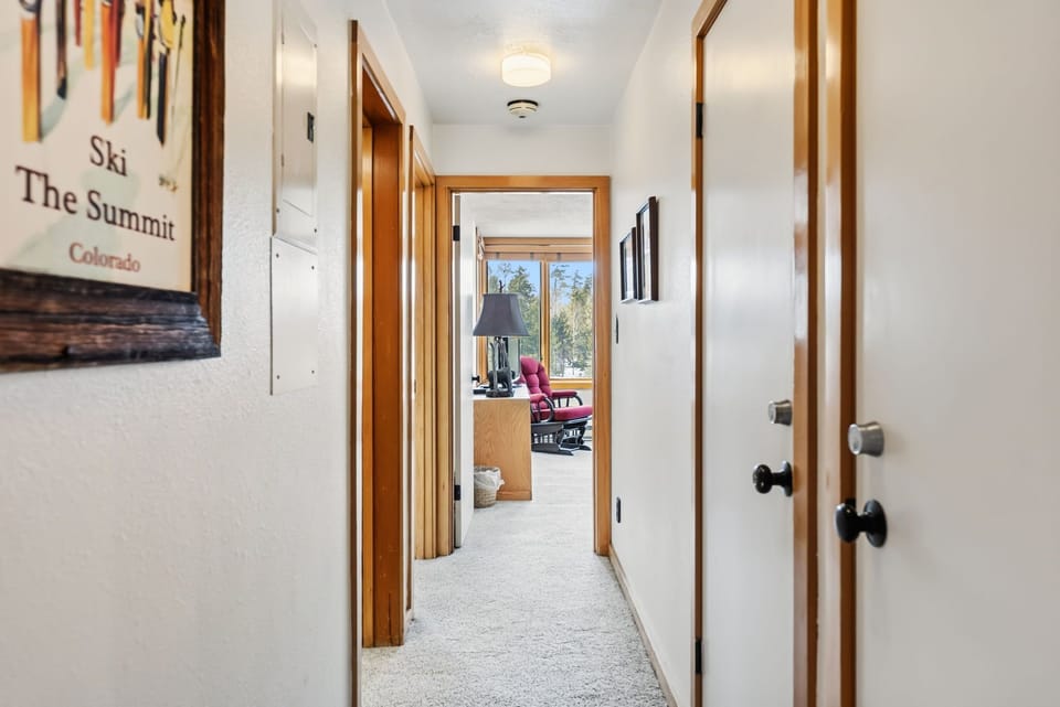 Walk down this bright hallway to your comfortable spaces, with ski-themed artwork adding mountain charm to your Colorado retreat.
