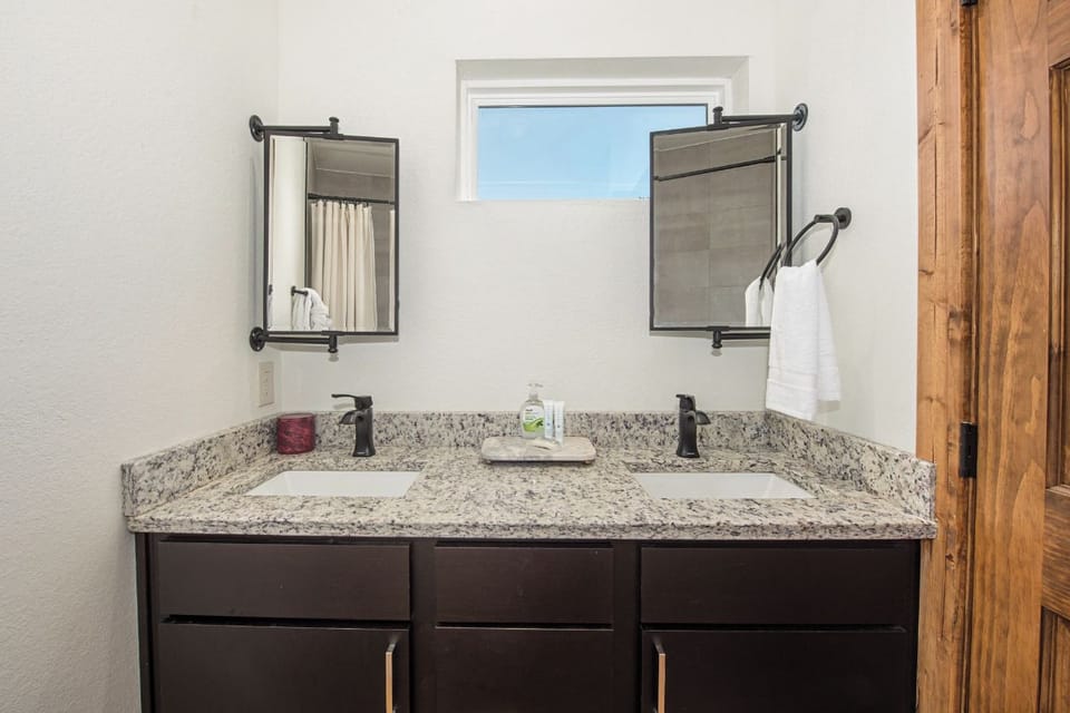 Freshen up at your private double vanity with sleek granite counters, modern fixtures, and plenty of natural light streaming through the window above.