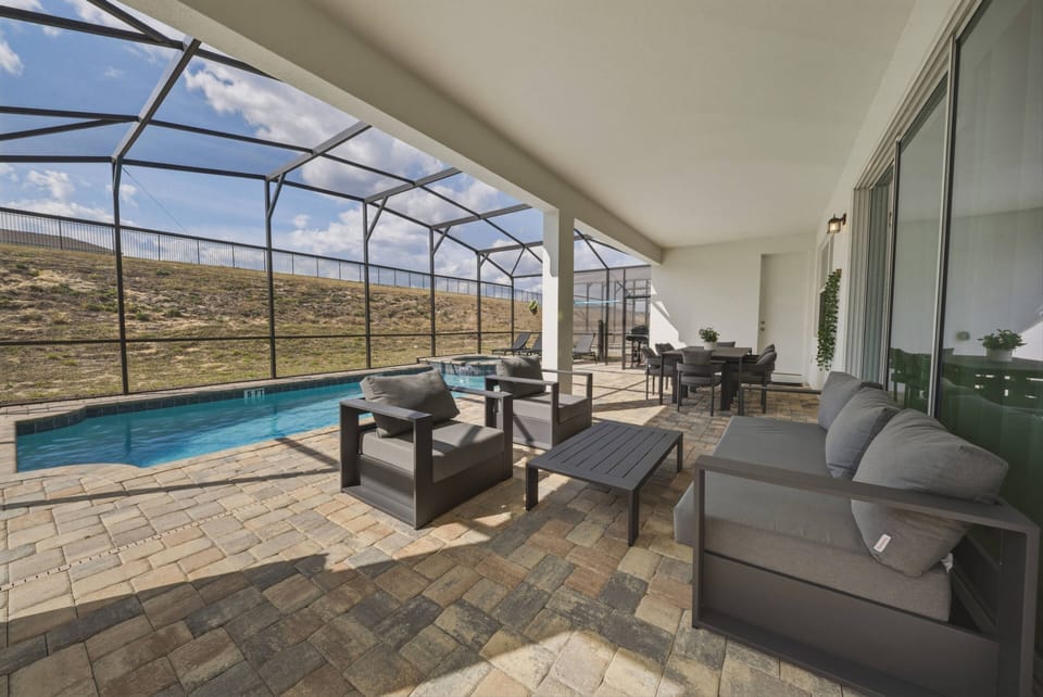 Step into your private oasis with a sparkling pool, sleek stone tiles, and cozy seating. Large screened windows let in natural light and provide stunning views of the peaceful landscape, ideal for your relaxation.