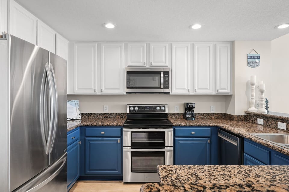 Your fully equipped kitchen features granite countertops, stainless steel appliances, and beautiful two-tone cabinetry for effortless meal preparation.
