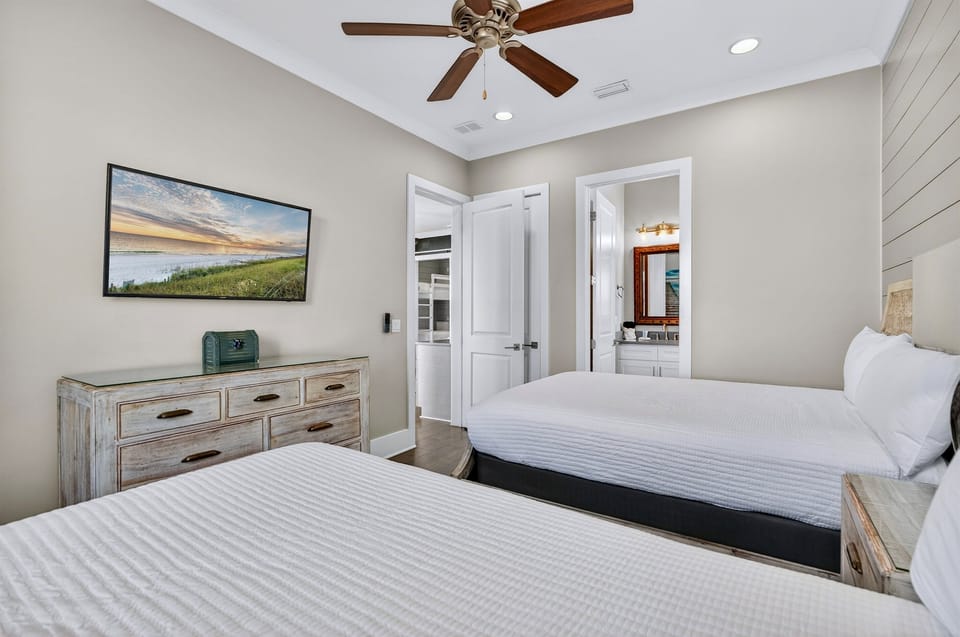 2nd Floor Double Queen Suite — Comfortable bedroom with two queen beds, a 4K Smart TV, and a private en-suite bathroom, ideal for families or guests sharing a stylish, spacious retreat on the second floor.