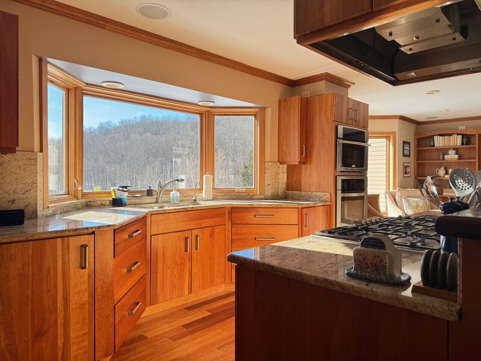 Cook with a view in this well-equipped kitchen featuring large windows.