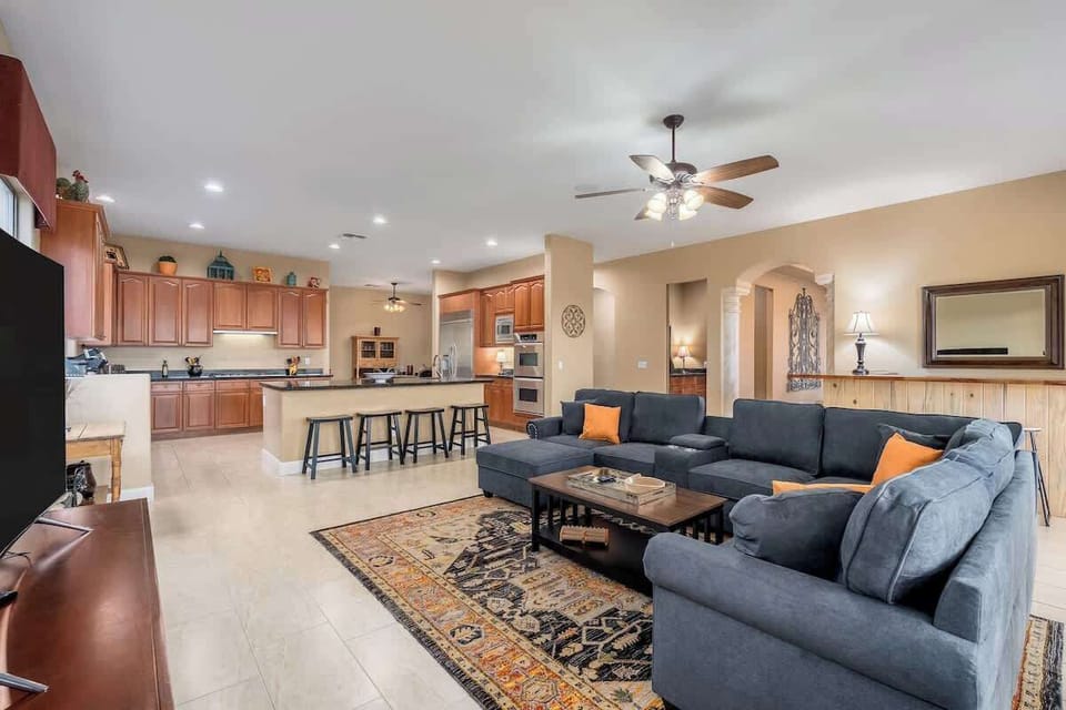 Picture yourself relaxing in this open-concept living space, where a plush sectional sofa invites you to unwind while staying connected to the fully equipped kitchen—perfect for group gatherings and quality time together.