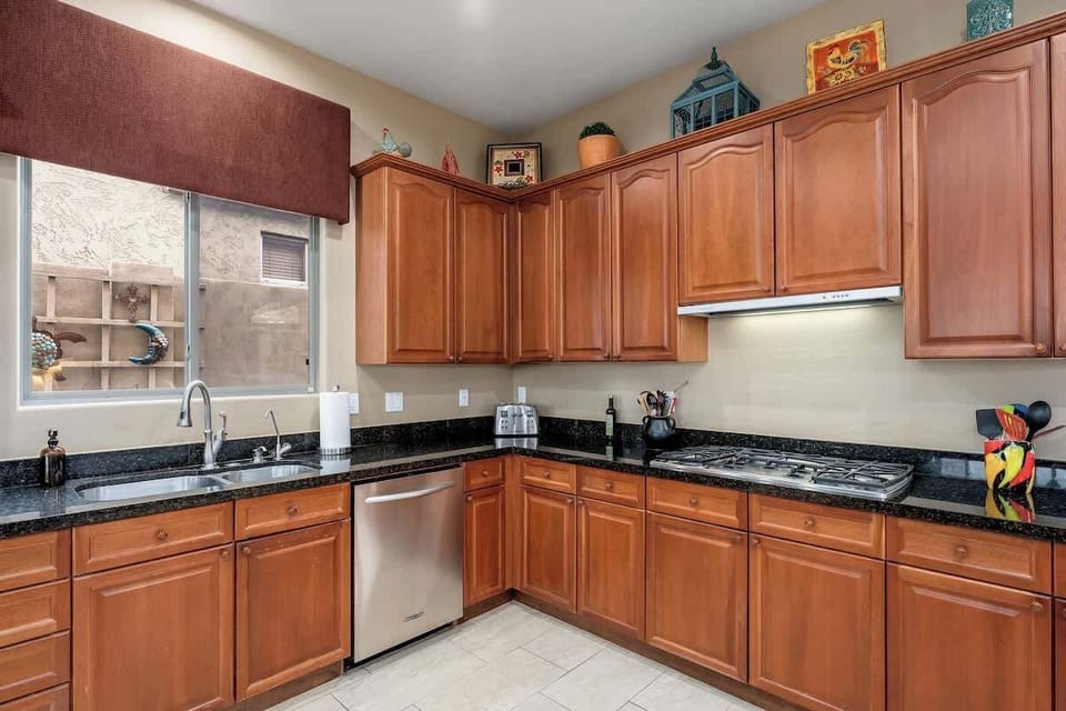 Step into your fully equipped kitchen with warm wood cabinetry, granite counters, stainless appliances, and a gas range ready for your culinary creations.