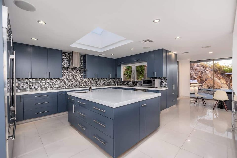 Step into a chef's dream with sleek navy cabinetry, gleaming quartz counters, and abundant natural light. The center island invites you to gather, cook, and create lasting memories.