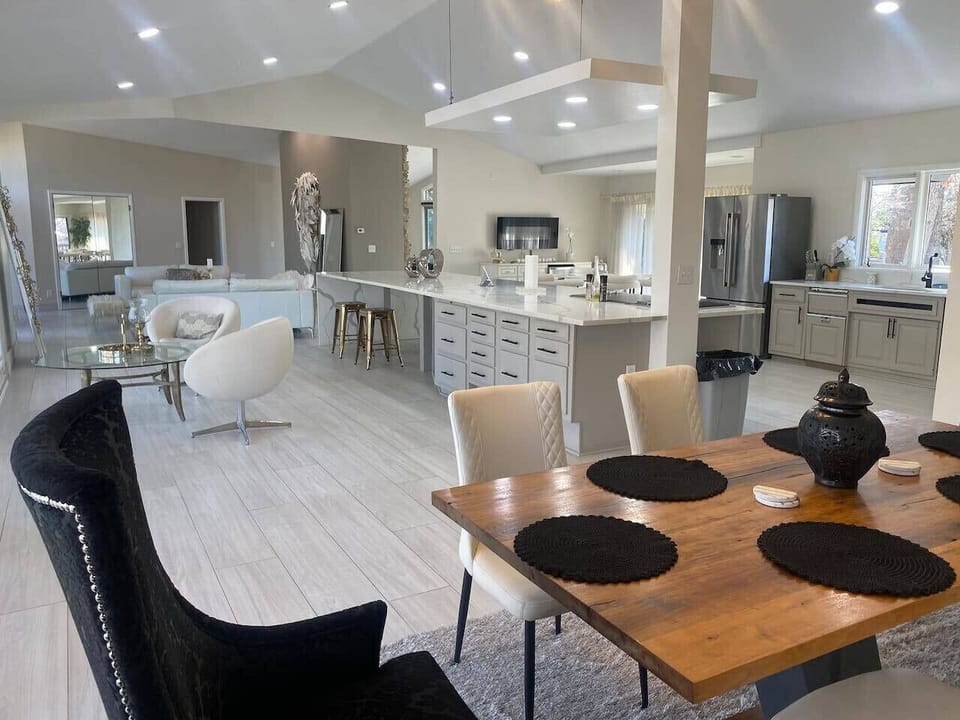 Dining area with wooden table, modern chairs and kitchen view
