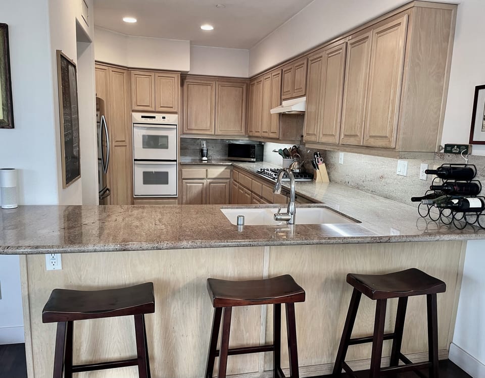 Modern, fully equipped kitchen with new appliances, eat-in counter.