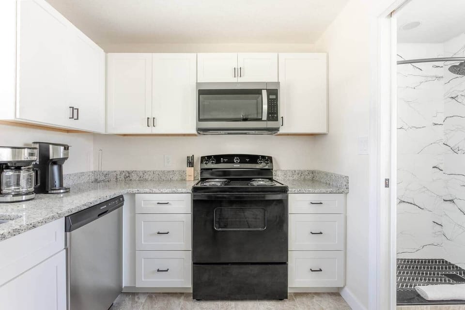 View of full kitchen, showing access to the full bathroom with walk-in shower, to the right