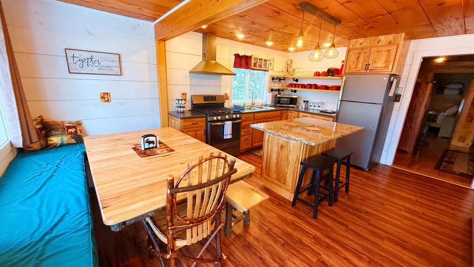 Rustic cabin kitchen with granite countertops, a spacious island, and cozy dining space perfect for gathering with family and friends.