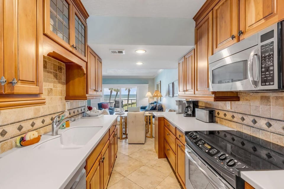 Spacious kitchen with warm wood cabinetry and modern appliances
