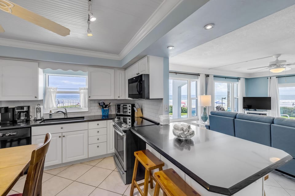 Bright, open kitchen with ocean views and cozy seating