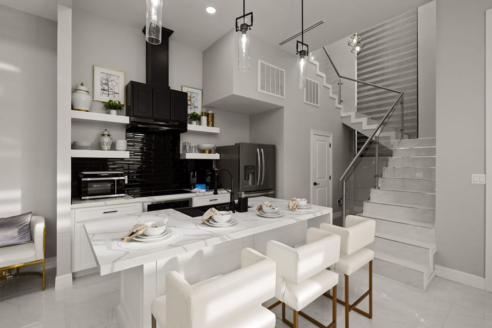 Spacious kitchen with breakfast bar seating and modern staircase leading to the upper level.