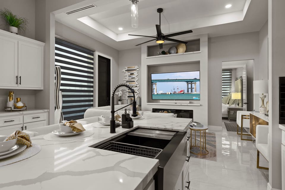 Open-concept kitchen and living area with island seating and abundant natural light.